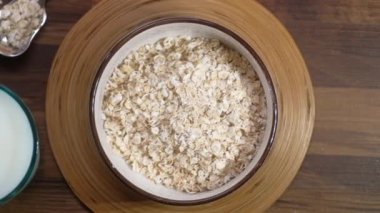 Yulaf gevreği bir kâsede süt masada. 