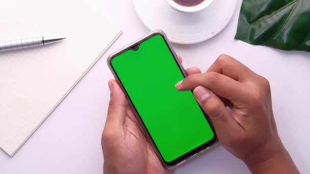 Young man hand holding smart phone with green screen — Stock Video