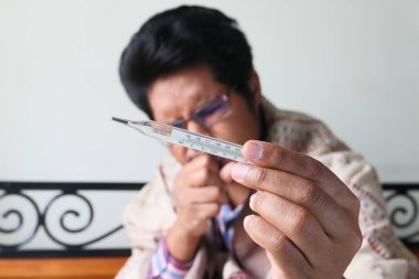 Eldeki vücut ısısını ölçmek için tıbbi termometre.