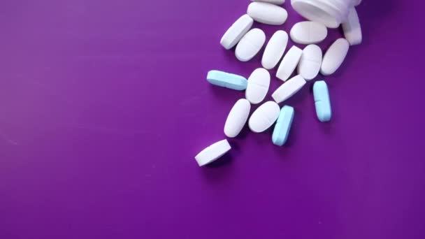 White pills spilling on pink background, Top view — Stock Video