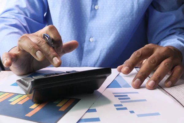 Рука бизнесмена с помощью калькулятора на рабочем столе — стоковое фото