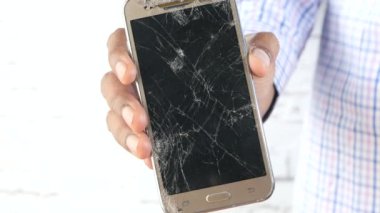 Boş ekranlı kırık akıllı telefonu tutan el. 