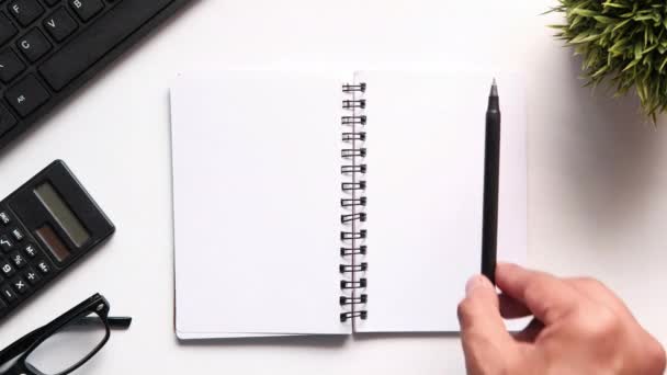 Top view of notepad and pen on white background — Stock Video