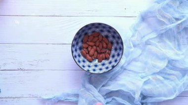 Kavrulmuş badem tabağa düşüyor..