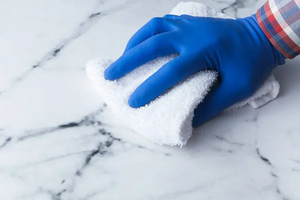 Ręka w niebieskie rękawice gumowe stół czyszczący — Zdjęcie stockowe