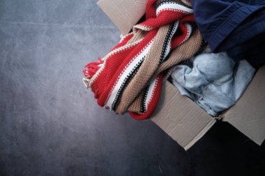 Tahta bir masanın üzerinde bağış giysileri olan bağış kutusu. .