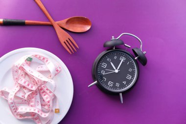 Diyet konsepti, boş tabakta çatal ve kaşıkla şerit ölçme