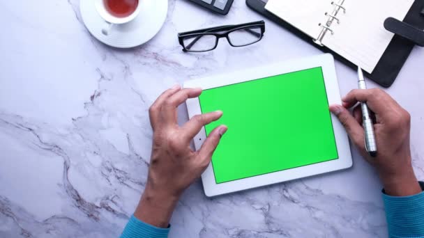 Giovane che lavora su tablet digitale con schermo verde — Video Stock