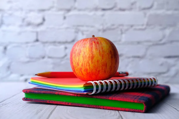 Крупним планом яблуко на стосі блокнотів на столі . — стокове фото