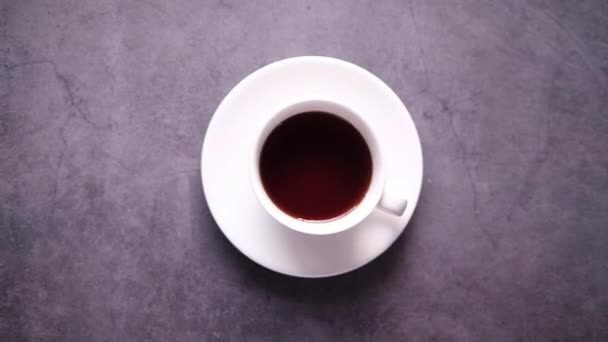 お茶のカップに砂糖のキューブが落ちるのトップビュー — ストック動画