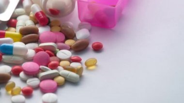 Beyaz arka planda ilaç kutulu renkli haplar 