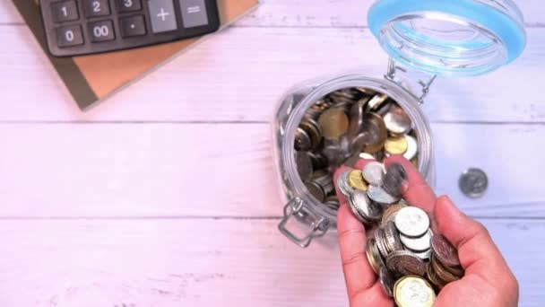 Vista superior do homem mão derramando moedas em um frasco — Vídeo de Stock