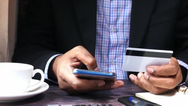 Чоловік тримає кредитну картку і використовує смартфон, концепцію інтернет-покупки — стокове відео