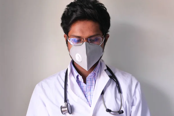 Γιατρός με μάσκα προσώπου κοιτάζοντας κάτω — Φωτογραφία Αρχείου