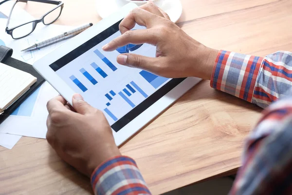 Businessman hands analyzing chart on digital tablet at office desk