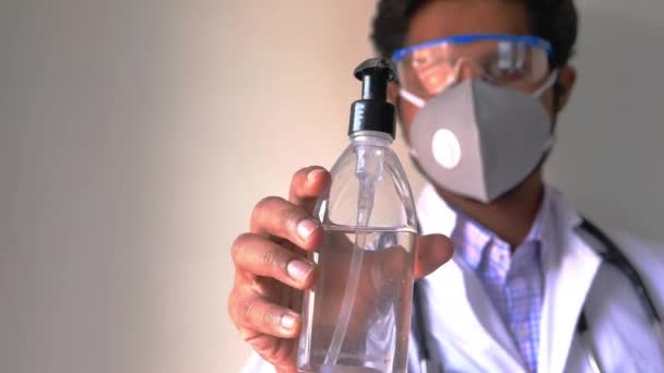 Arzt mit Gesichtsmaske Hand hält Desinfektionsmittel mit Kopierraum — Stockvideo