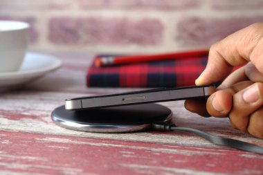 Kablosuz şarj pedi kullanarak akıllı telefon şarj ediliyor, üst görünüm 