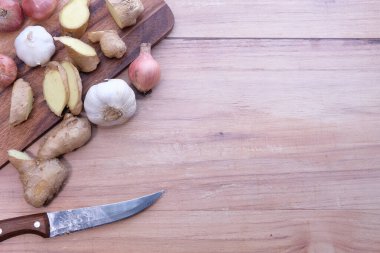 Zencefil, sarımsak ve soğan doğrama tahtasında.