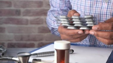 Doktorun elinde farklı tablet kabarcıkları var..