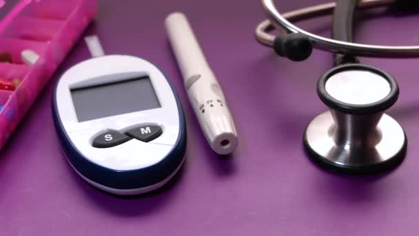 Kits de medição de açúcar no sangue para diabetes com caixa de pílula sobre fundo de cor — Vídeo de Stock