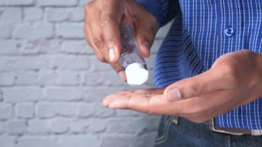 Delikanlı el dezenfektanı kullanıyor. 