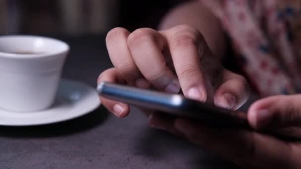 Primer plano de una mano de mujer usando un teléfono inteligente . — Vídeos de Stock