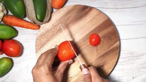 Vue du dessus de l'homme mains coupant la tomate — Video