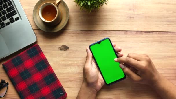 Рука бизнесмена с помощью смартфона с зеленым экраном на столе — стоковое видео