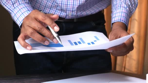 Бізнесмен аналізує фінансові дані на офісному столі — стокове відео