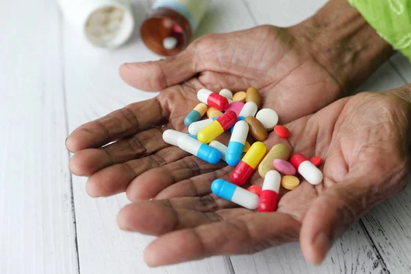 senior women hands taking medicine, close up