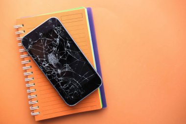  Turuncu arka planda boş ekran ile kırılmış akıllı telefon 
