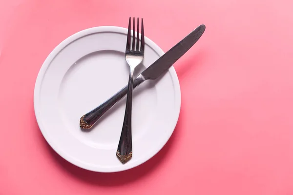 Prato limpo e talheres no fundo rosa — Fotografia de Stock