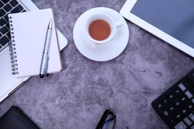 Gri arkaplanda dizüstü bilgisayar ve ofis sağlayıcılarının yüksek açılı görünümü 