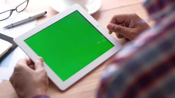 Молодой человек работает на цифровой планшет с зеленым экраном — стоковое видео