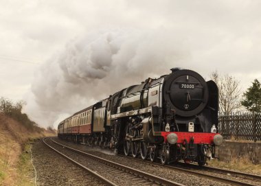 Buharlı lokomotifi Britanya 'da muhafaza etmiş, Cumbrian Muhafız' ını Langwathby istasyonuna yönlendiriyor, Kuzey İngiltere 'deki Carlisle Demiryolu' na yerleşiyor..