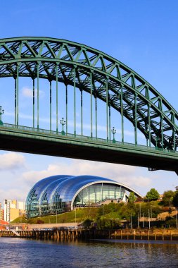 Tyne Köprüsü Kuzey Doğu İngiltere 'de Tyne ve Gateshead üzerinde Newcastle' ı birbirine bağlıyor. Arkasında müzikal eğitim ve performans için sembolik bir bilge merkezi var..