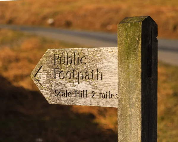 Public Footpath Sign.  A wooden signpost marking a public footpath close to Crummock Water in the English Lake District national park.