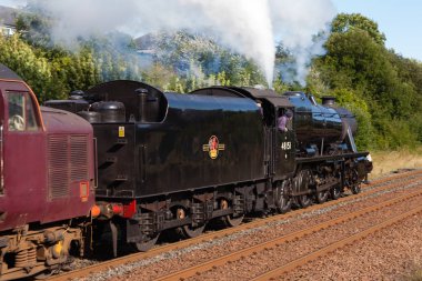 48151 numaralı buharlı lokomotif İngiltere 'nin Appleby şehrinden Carlisle demiryoluna gitmek üzere güneye doğru yola çıkıyor..