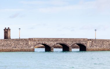 Toplar Köprüsü. Puente de las Bolas, İspanya 'nın Lanzarote adasındaki Arrecife limanındaki San Gabriel Kalesi' ne gidiyor..