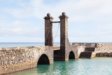 Toplar Köprüsü. Puente de las Bolas, İspanya 'nın Lanzarote adasındaki Arrecife limanındaki San Gabriel Kalesi' ne gidiyor..