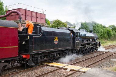 Buhar treni 45690, Leander, Cumbria, İngiltere 'deki Appleby' den Carlisle Demiryolu 'na kadar su alıyor..