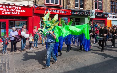 İngiltere 'nin Penrith şehir merkezi Cumbria' da düzenlenen yıllık Mayıs Bayramı geçit törenine yeşil ve mavi bir ejderha katılıyor..