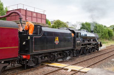 Buhar treni 45690, Leander, Cumbria, İngiltere 'deki Appleby' den Carlisle Demiryolu 'na kadar su alıyor..