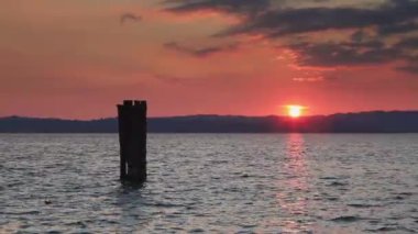 Garda Gölü Günbatımı. İtalya 'da Garda Gölü üzerinde gün batımı Sirmione rıhtımından izleniyor.