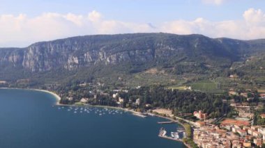 Garda Timelapse. Rocca 'dan Garda kasabasına doğru bir hava manzarası. Garda, İtalya 'nın kuzeydoğusunda Garda Gölü' nün kıyısında yer alan bir kasabadır..