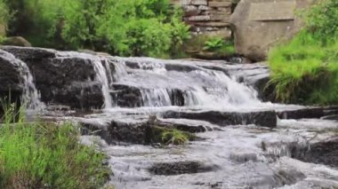 İngiltere 'nin Batı Yorkshire kentindeki Haworth yakınlarındaki Bronte Şelalesi' nin altındaki Güney Dean Beck 'in yavaş çekim görüntüsü.