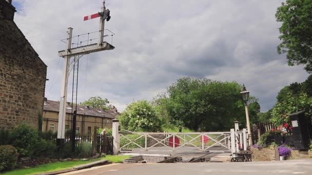 Der Bahnhofsvorsteher Oakworth Station Öffnet Die Bahnübergangstore Der Bahnhof Liegt — Stockvideo