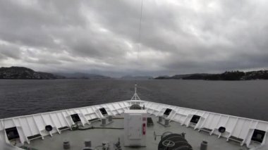 Bergen Fjord. Norveç 'te Bergen fiyordunda seyahat eden bir geminin pruvasına bakan bir zaman kaydı..
