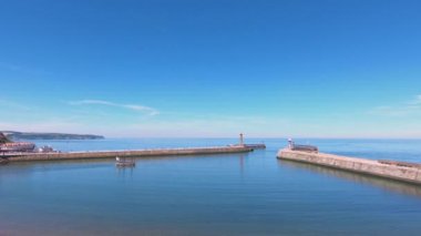 Whitby Limanı. Kuzey Yorkshire 'ın kuzey İngiltere' deki Whitby limanının karşısındaki manzara bir turist eğlence gemisi olarak hareket ediyor..