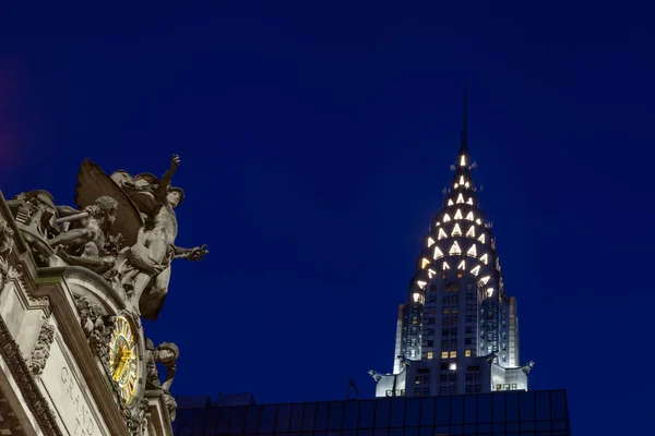 Amerika Birleşik Devletleri 'nin New York şehrindeki Grand Central İstasyonu' nu süsleyen Ticaret İhtişamı heykelinin gece manzarası. Arka planda Chrysler Binası var..
